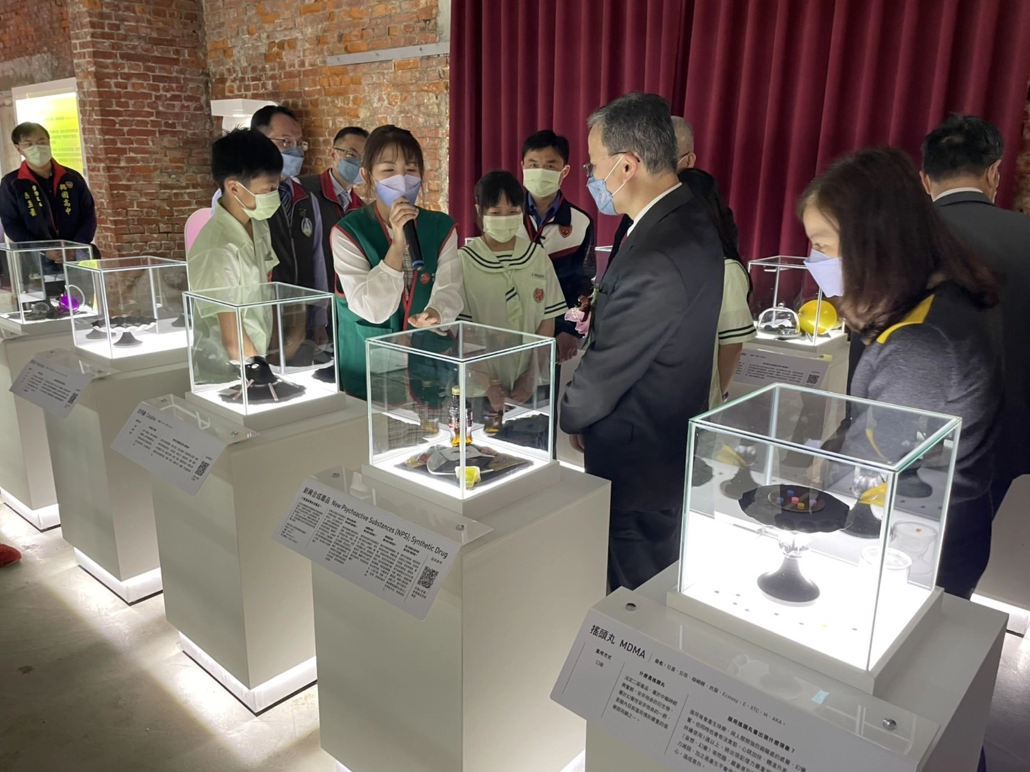 教育部學務特教司司長與參觀特展學生們仔細聆聽導覽人員解說仿真毒品及實際危害