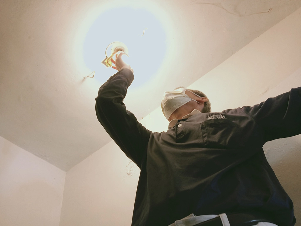 志工在林老太太樓梯口裝置省電 LED燈照明。