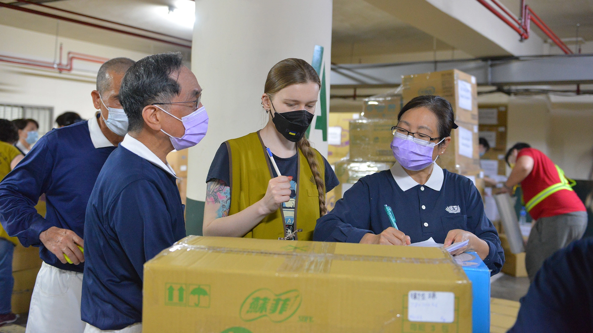 烏克蘭籍在台僑民鄭莎莎(左三)於14日特別前往外交部擔任援助烏克蘭難民物資打包志工。