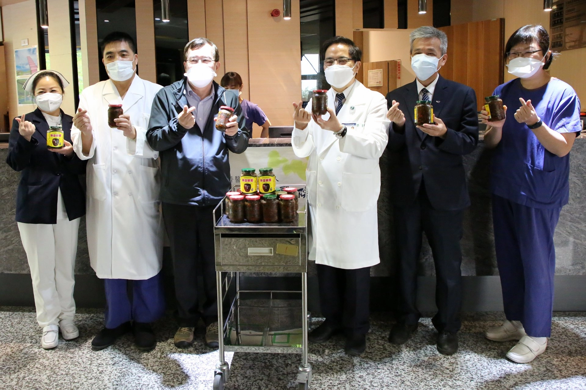 花蓮慈濟醫院院長林欣榮、副院長羅慶徽、主任秘書陳星助與護理部主任鍾惠君於五月三日帶著淨斯本草滴露、福慧粥以及靜思精舍師父製作的美味辣味蔭豆鼓，為防疫旅館的進駐同仁、工作人員加菜、補充元氣。