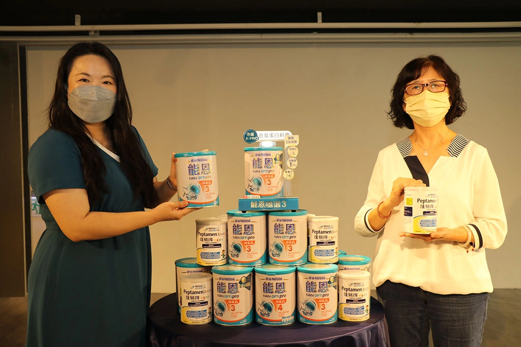 雀巢嬰幼兒營養品事業部總監蔡家雯（左）代表捐贈1.8萬罐能恩奶粉予新北市弱勢兒少，由社會局副局長許秀能代收。
