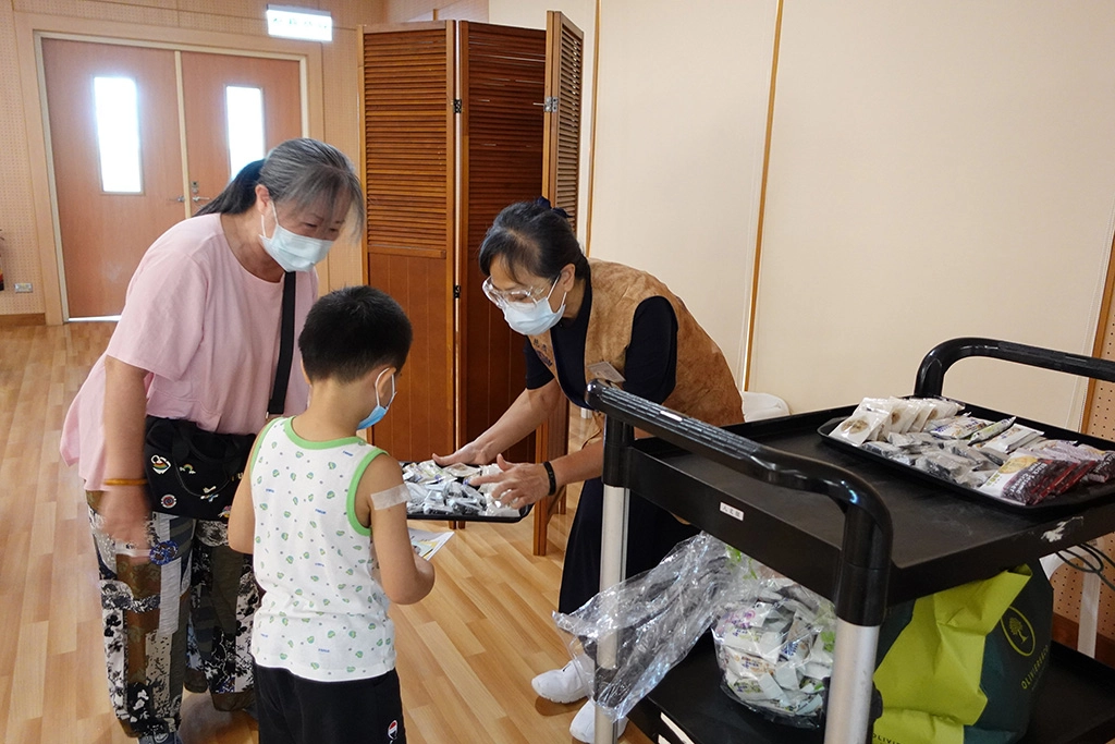 慈濟志工準備餅乾點心，讓小朋友不害怕來打針。