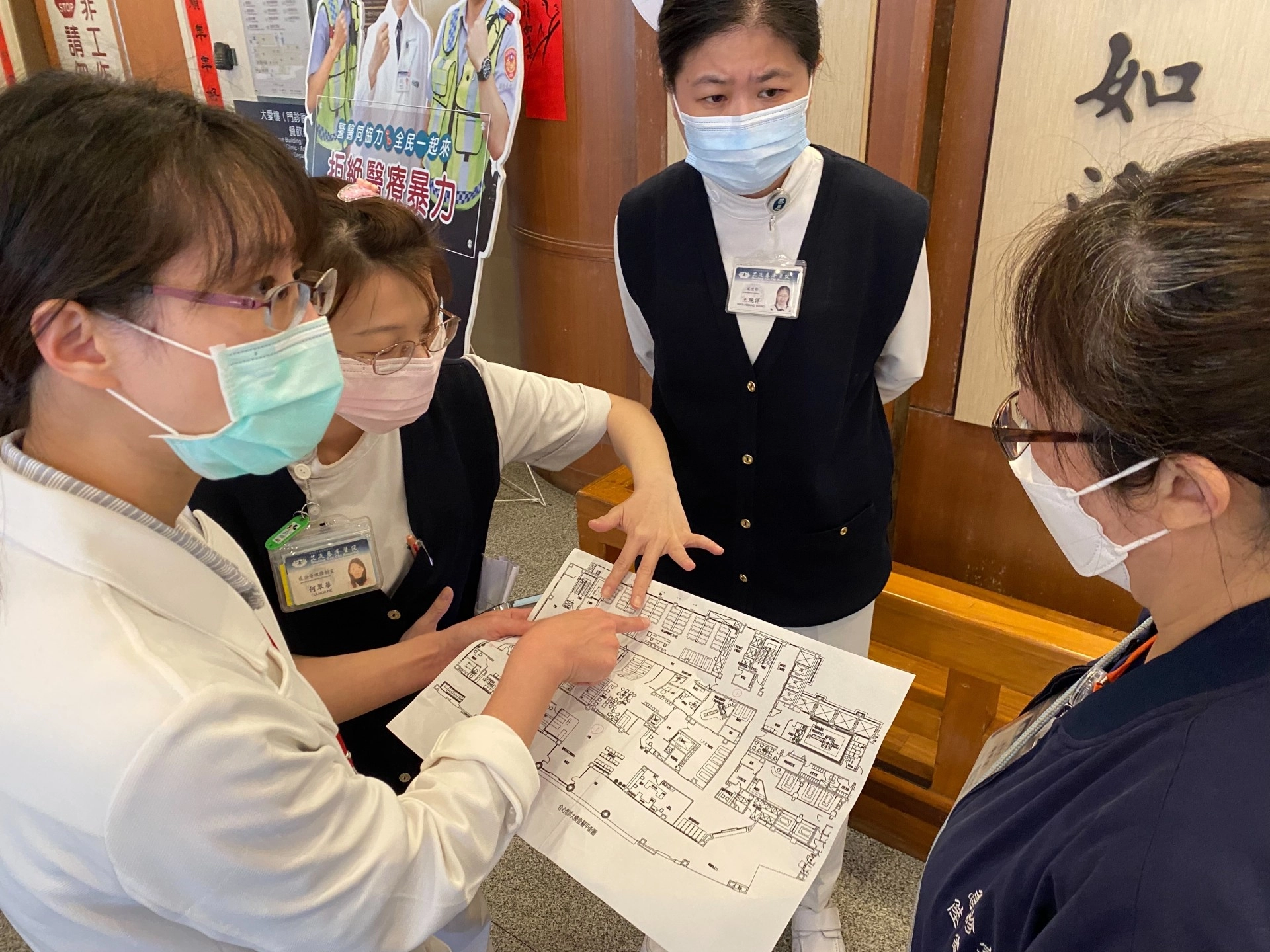 感管室主任黃妙慧醫師（左一）、感控護理師何翠華（左二）與急診室護理長陸家宜（右一）確認病床空間配置圖，右二為護理部副主任王琬詳。