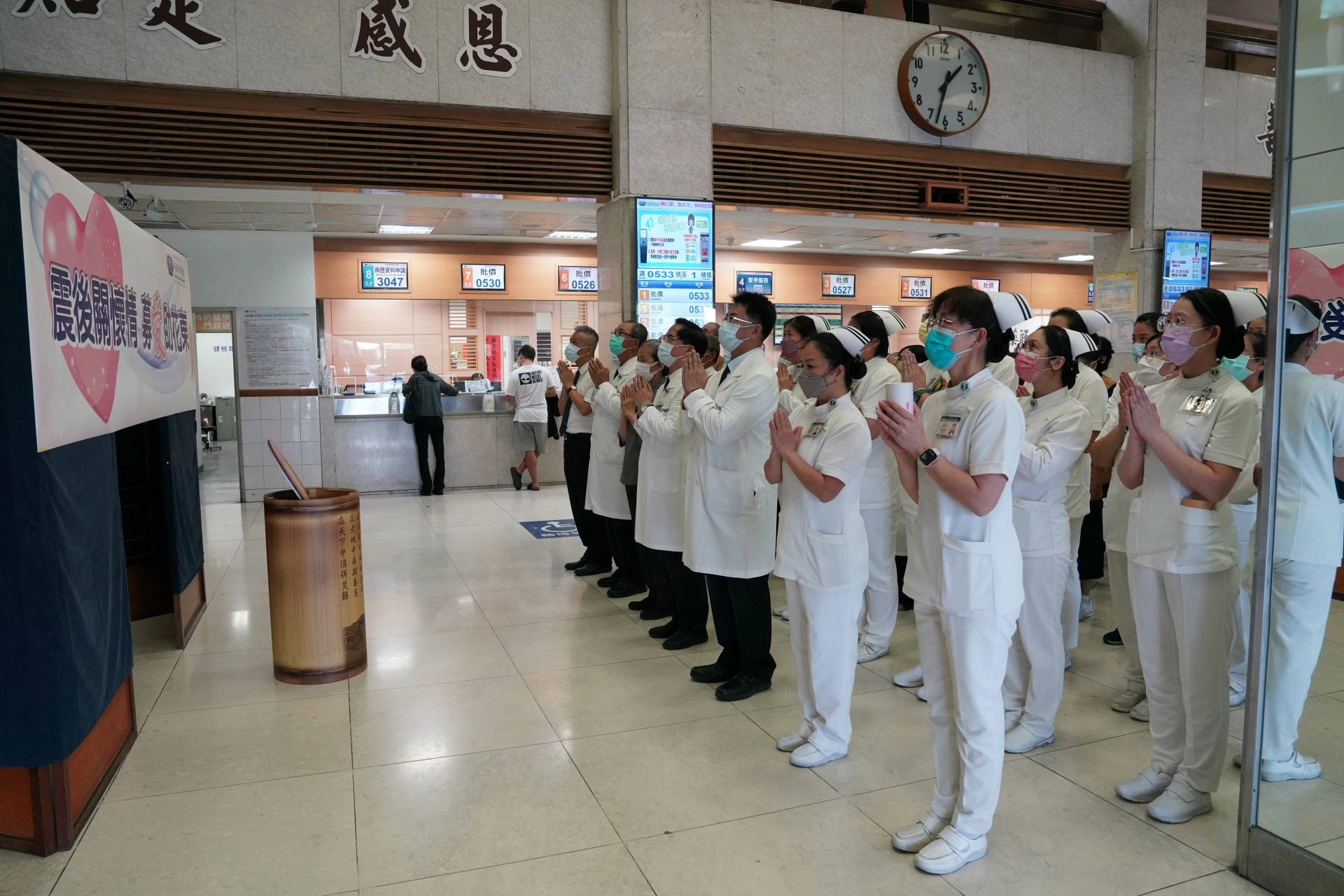 　十月三日下午，花蓮慈院啟動募心募愛活動，院長林欣榮(前排右三)等多位主管帶領同仁及醫療志工，在門診大廳佛陀問病圖前，合十唱頌「祈禱」祈福。