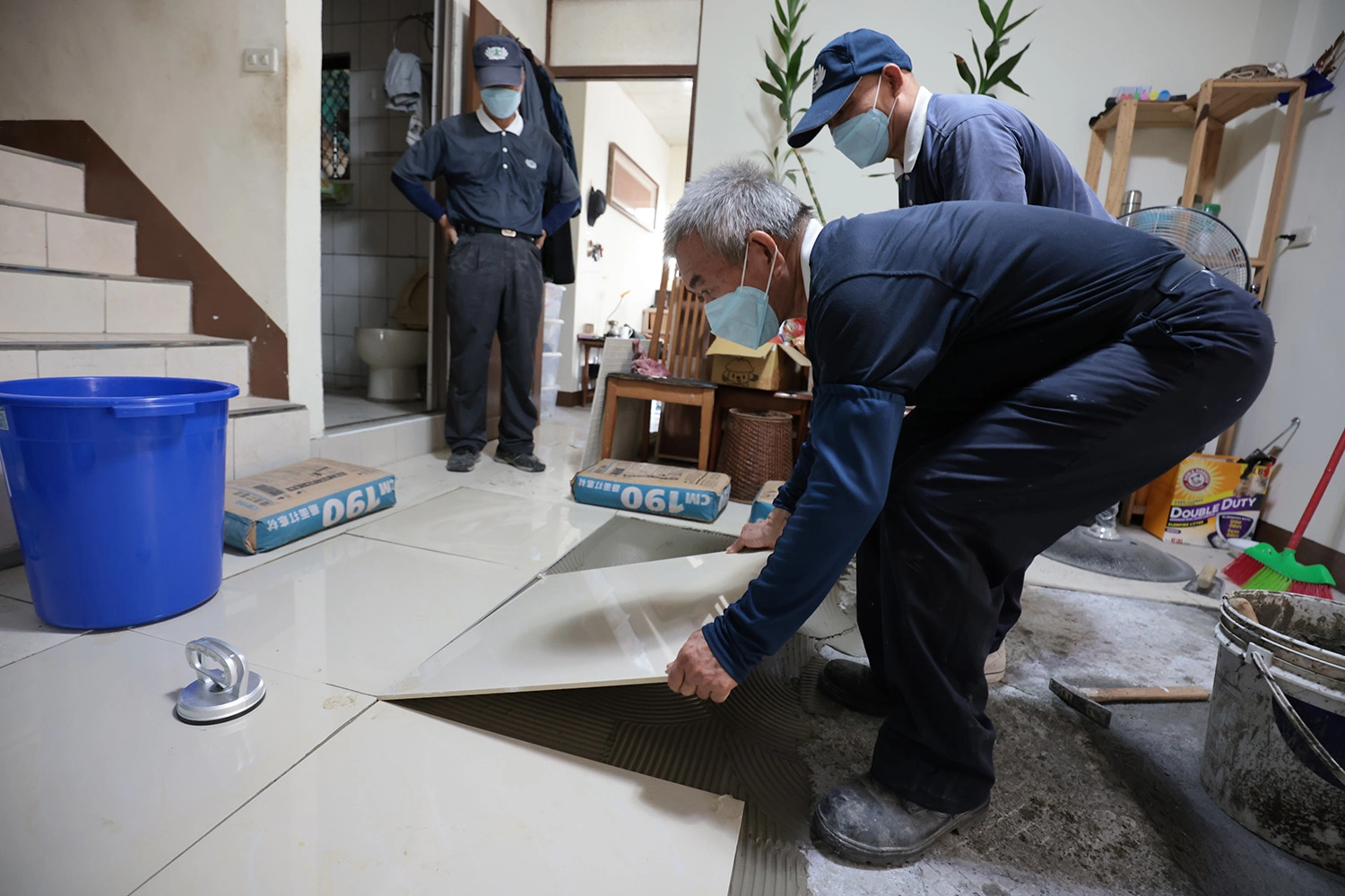 10月7日慈濟志工為魏爺爺家裏鋪設新磁磚。(攝影：楊凱誠)
