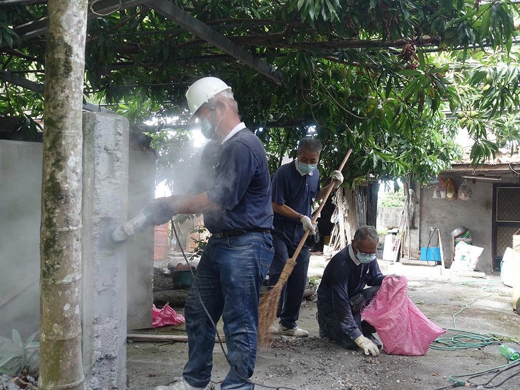 慈濟志工在玉里鎮源城里為民眾修繕，志工有的切牆、有的整理廢棄物。