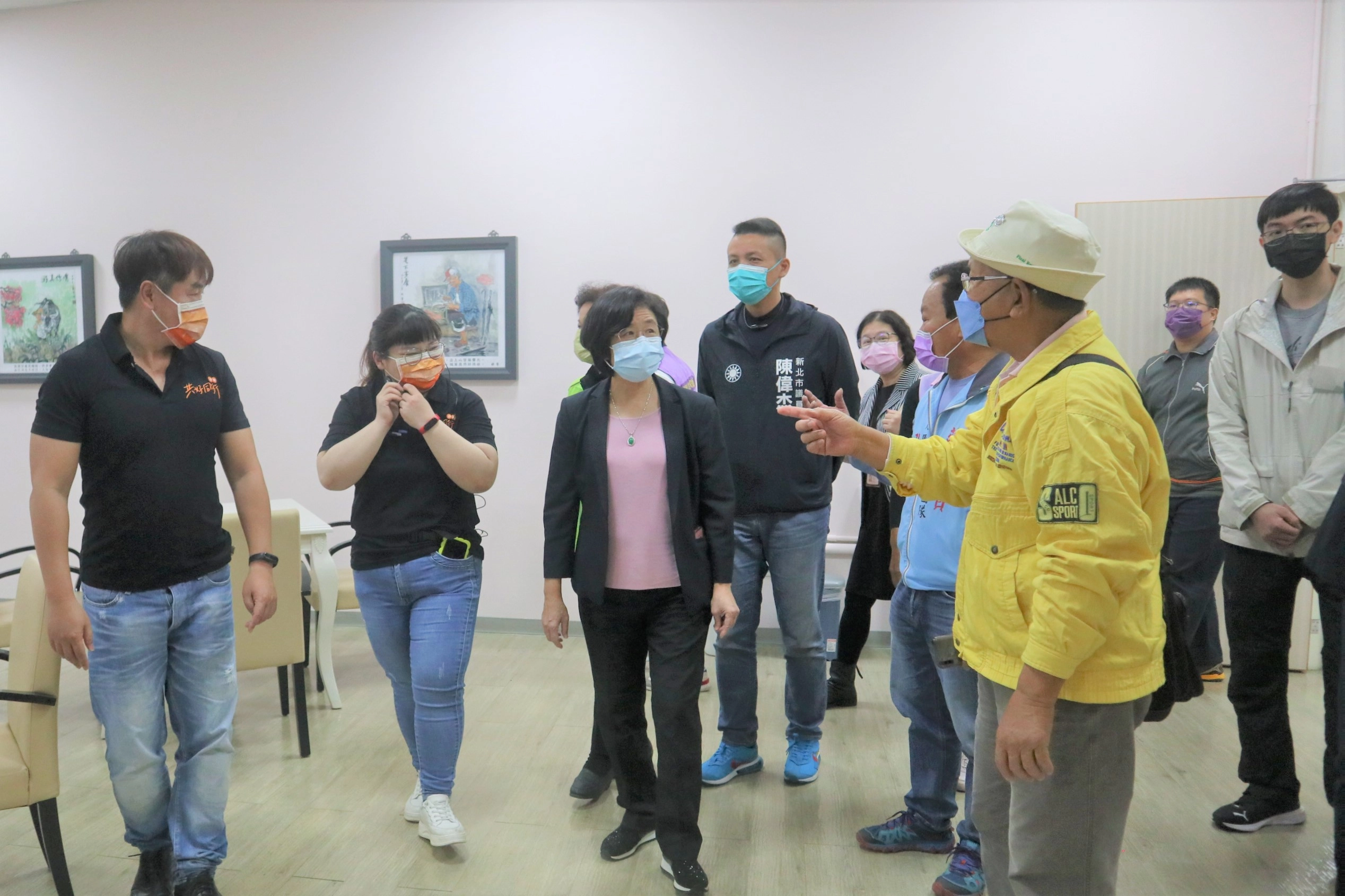 伊甸八里耆福綜合長照機構主任欣韻(左2)為局長陳潤秋與貴賓們進行導覽，介紹服務特色及環境規劃