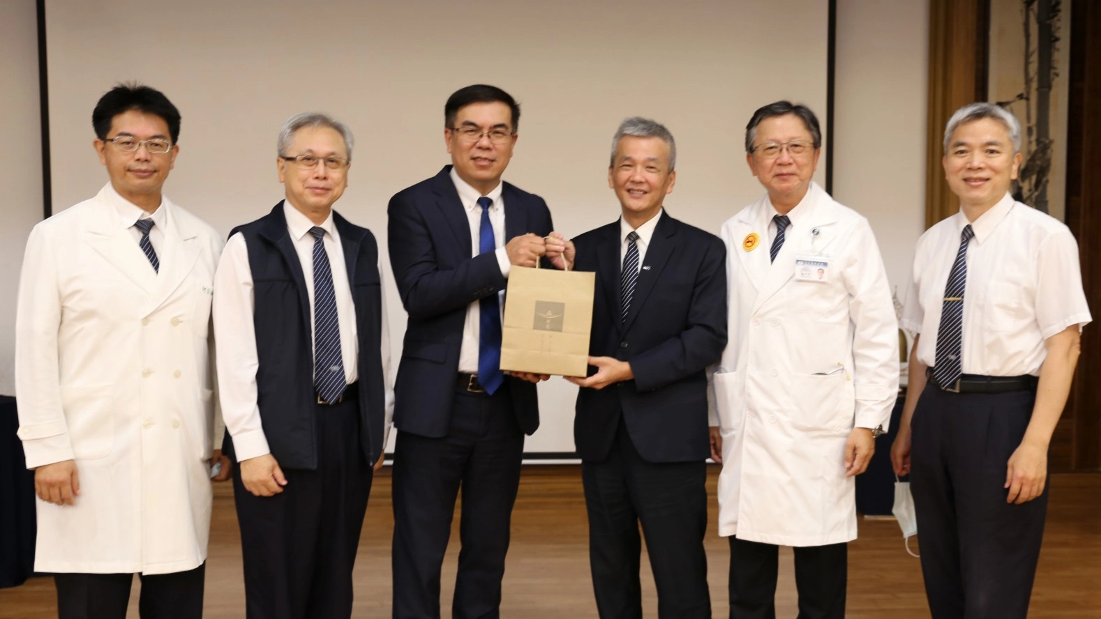 臺灣氣候聯盟秘書長彭啟明(左三)學術演講後，副院長陳星助(右三)致贈結緣品。副院長何宗融(左起)、花蓮慈濟醫院緩和醫學中心主任王英偉、彭啟明、陳星助、徐中平副院長、花蓮縣醫師公會理事長梁忠詔。