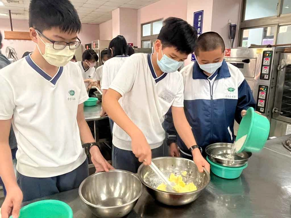 食品群的同學專注於攪拌，體會到餅乾製作真不簡單。