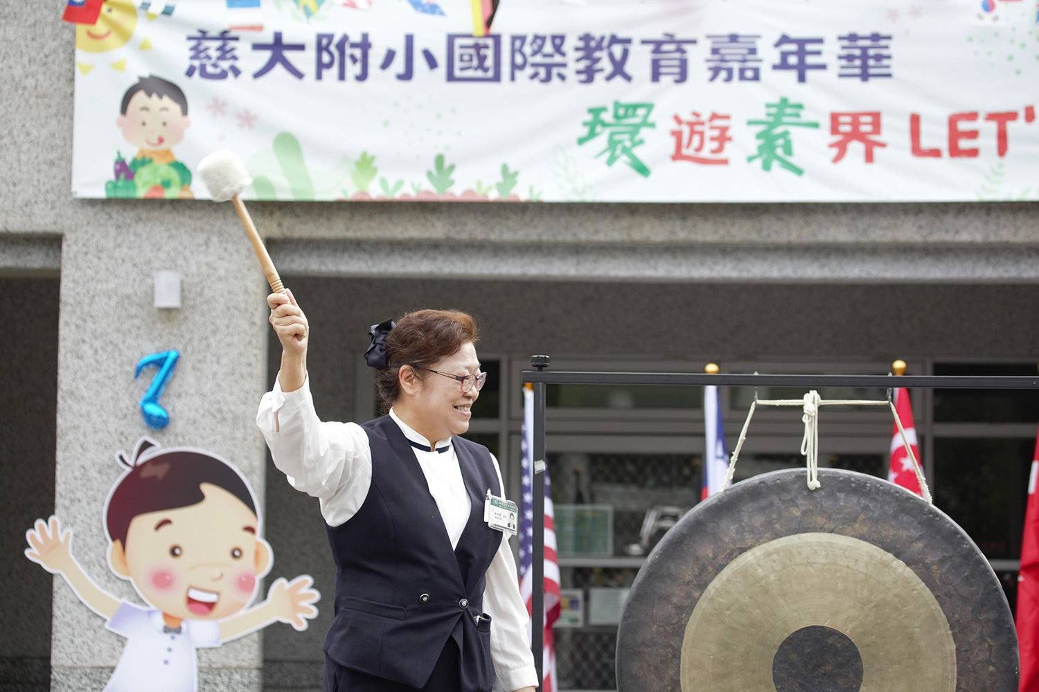 李玲惠校長敲響愛心鑼，慈大附小國際教育嘉年華~「環」遊「素」界Let’s go兒童節慶祝活動。