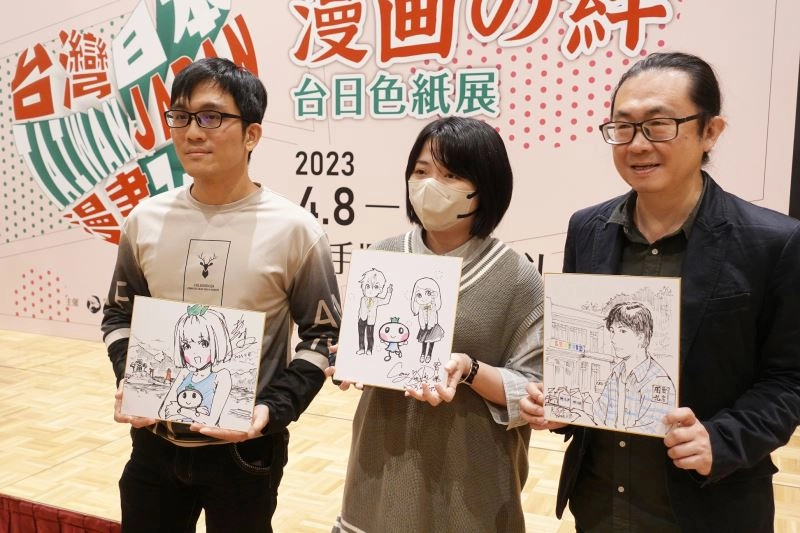 （左起）臺灣漫畫家彭傑、柯宥希、阮光民手持開幕式現場繪製的簽名板合影留念。