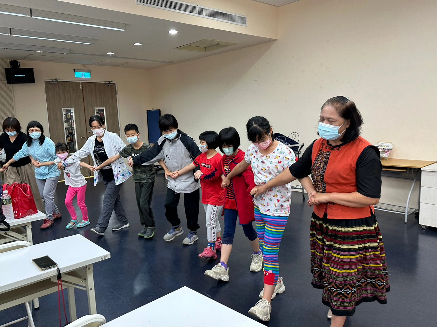 林富蘭講師(右一)教親子如河跳排灣族八步舞。