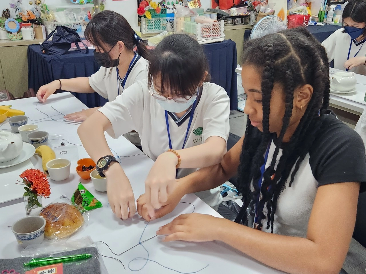 南慈大使細心引導外籍生如何製作無患子吊飾。