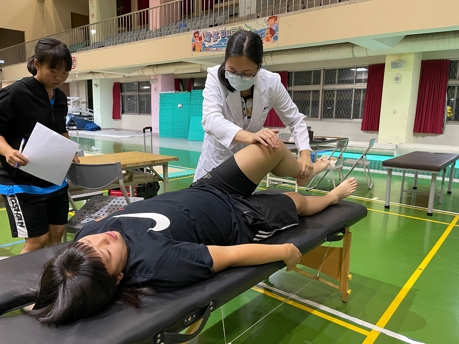 梁雅淳醫師（右）以中醫傷科手法為選手緩解腰部與腿部疼痛。