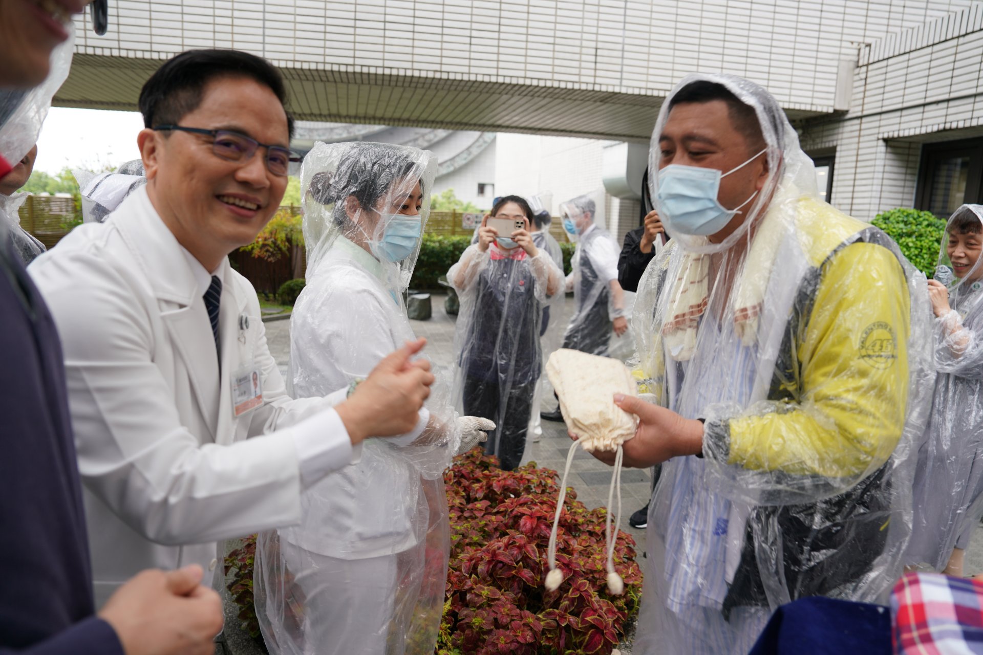 林欣榮院長(左)致贈志工親手縫製的Green Bag環保束口袋給病患，一起響應環保救地球。
