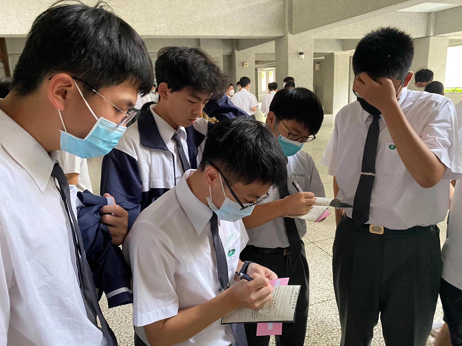 參加解謎遊戲的學生們在海報前邊討論邊尋找答案。(陳弈亘 攝)