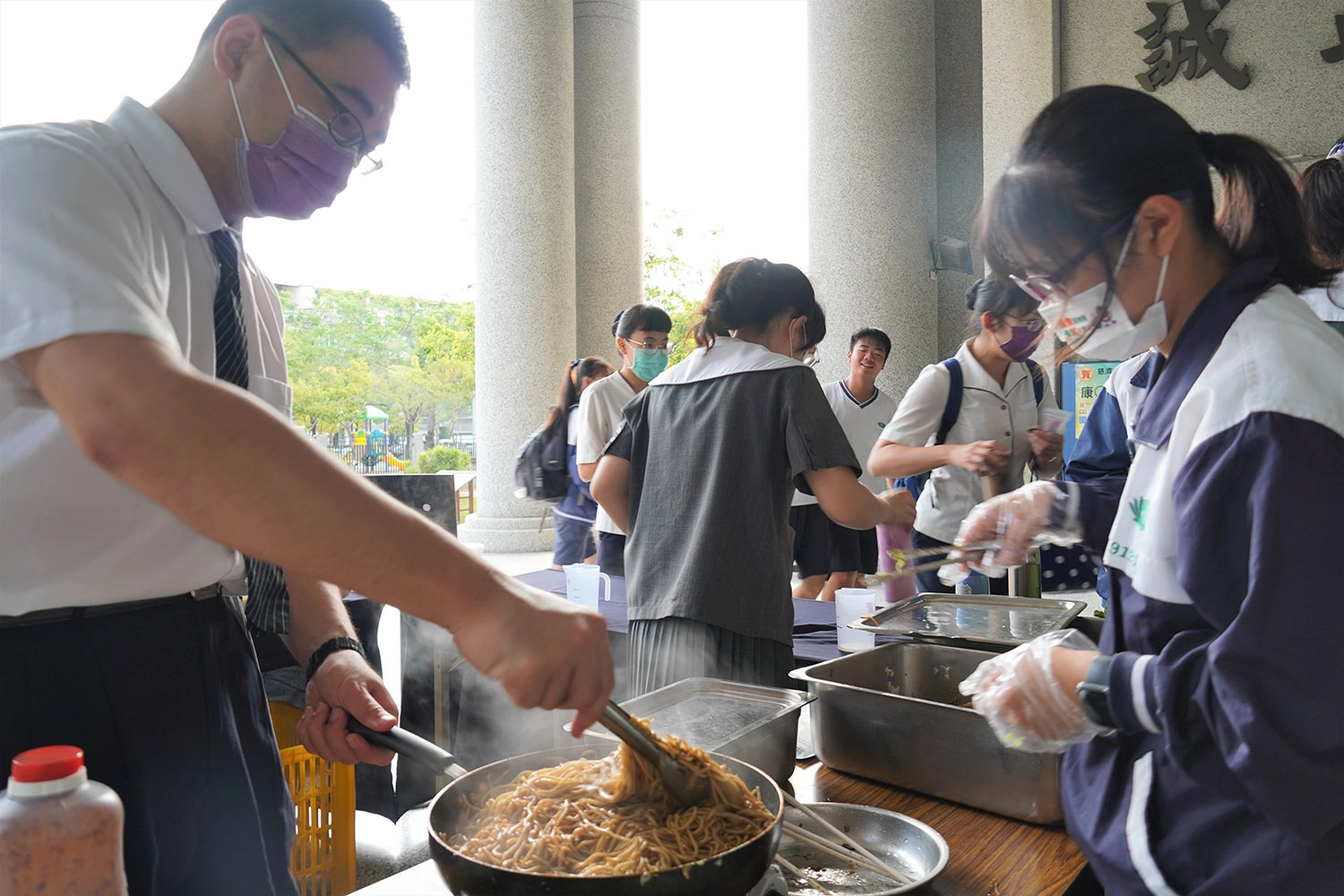 學務處吳念祖老師協助製作製作隱藏版的蔬食炒麵麵包。(林曉瑩 攝)