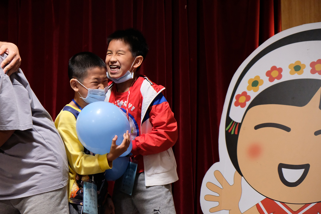 認養人的孩子與認養童開心地一起玩遊戲