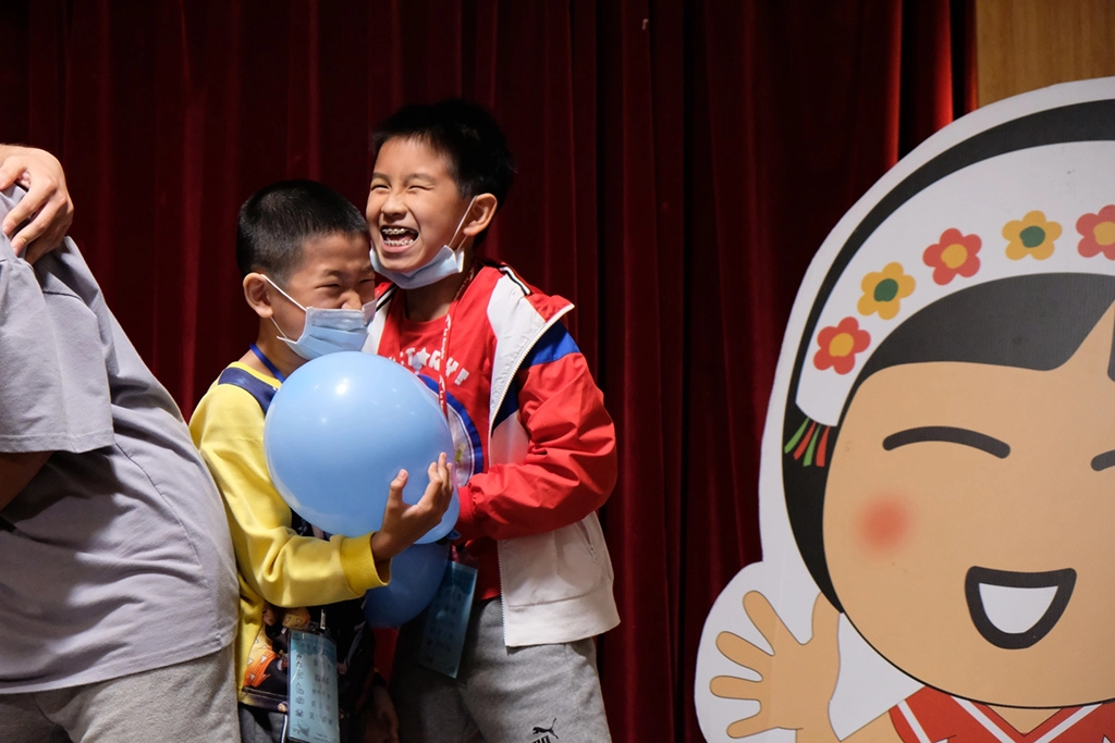 認養人的孩子與認養童開心地一起玩遊戲