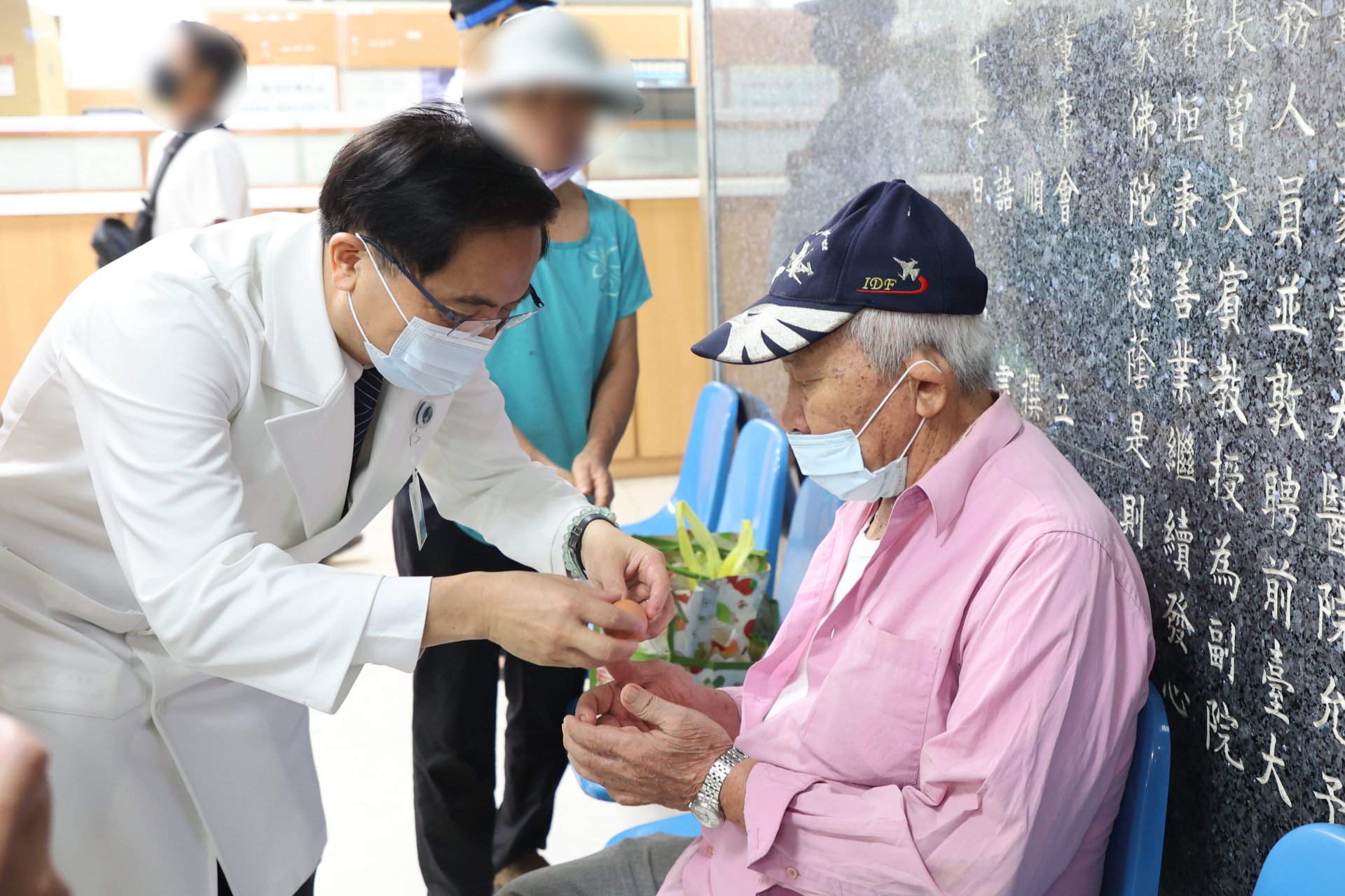 志工室主任顏靜曦也準備了喜氣洋洋的紅蛋，由林欣榮院長、醫務秘書李毅代表，在大廳與病人及家屬分享院慶喜悅。
