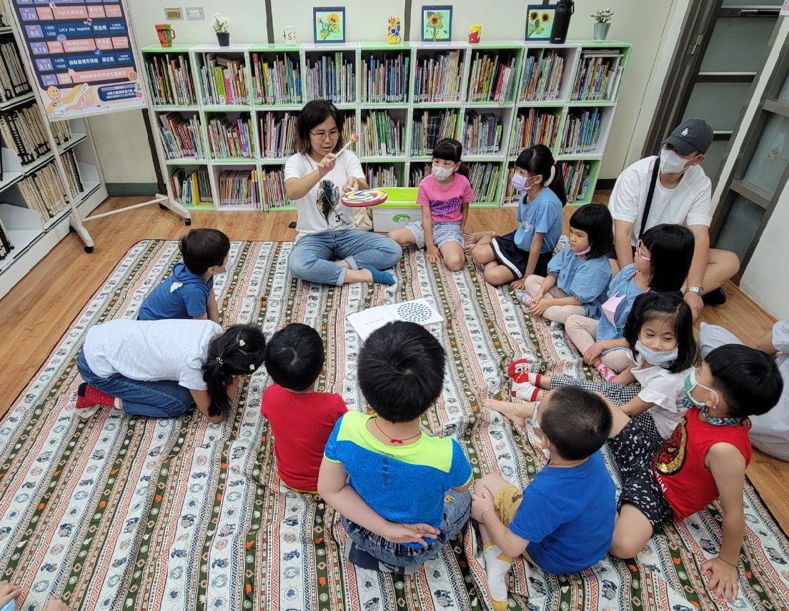 「 let's play together」郭金嬋老師以繪本和樂器與小朋友互動中。