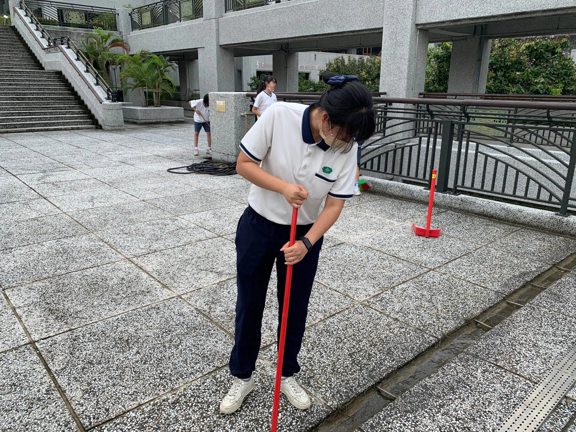 陳立祺老師執行身教，帶領同學清除水溝淤積泥沙及落葉。