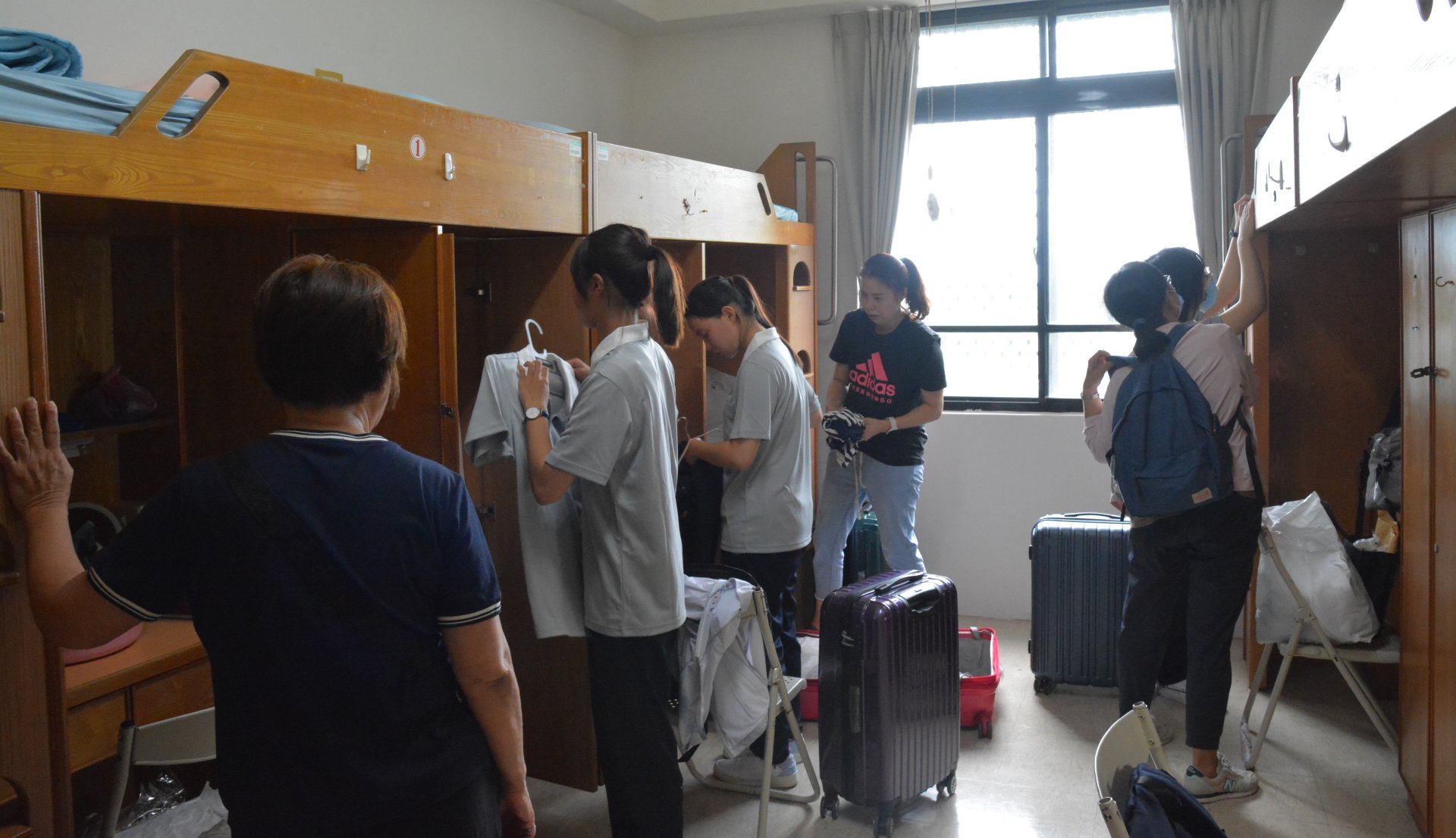 新生和家長將行李和寢具搬運到宿舍。