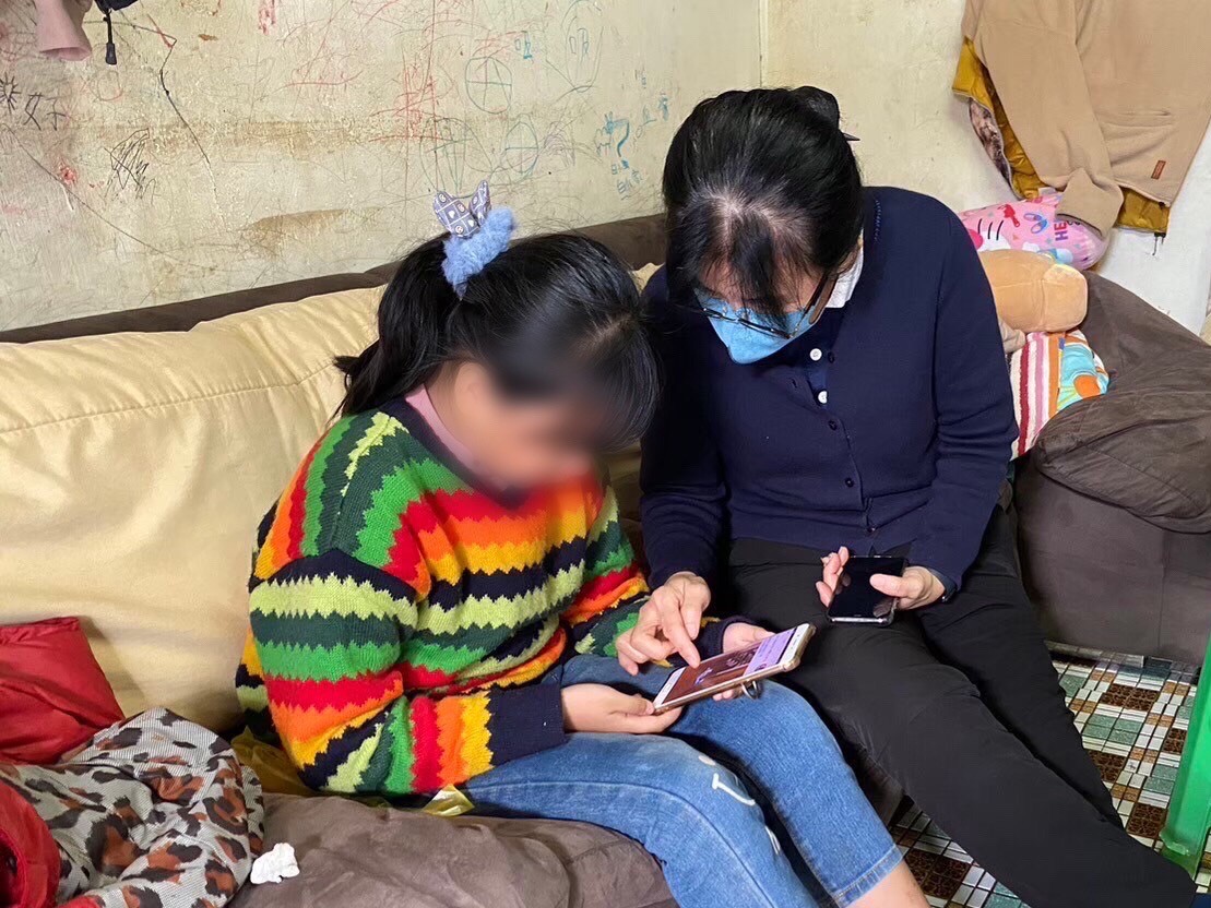 慈濟志工陪伴阿英的女兒,鼓勵上進。