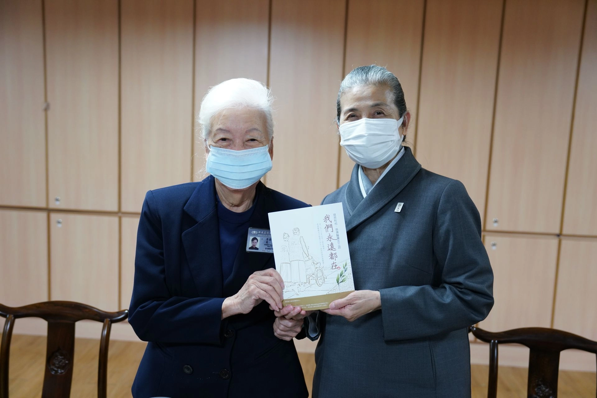 顏靜曦師姊最後致贈現場每位志工一本記載醫療志工38年來成長經過的《我們永遠都在：慈悲利他．慈濟醫療志工誌》，希望每位家人承襲法髓，繼續勇猛精進。
