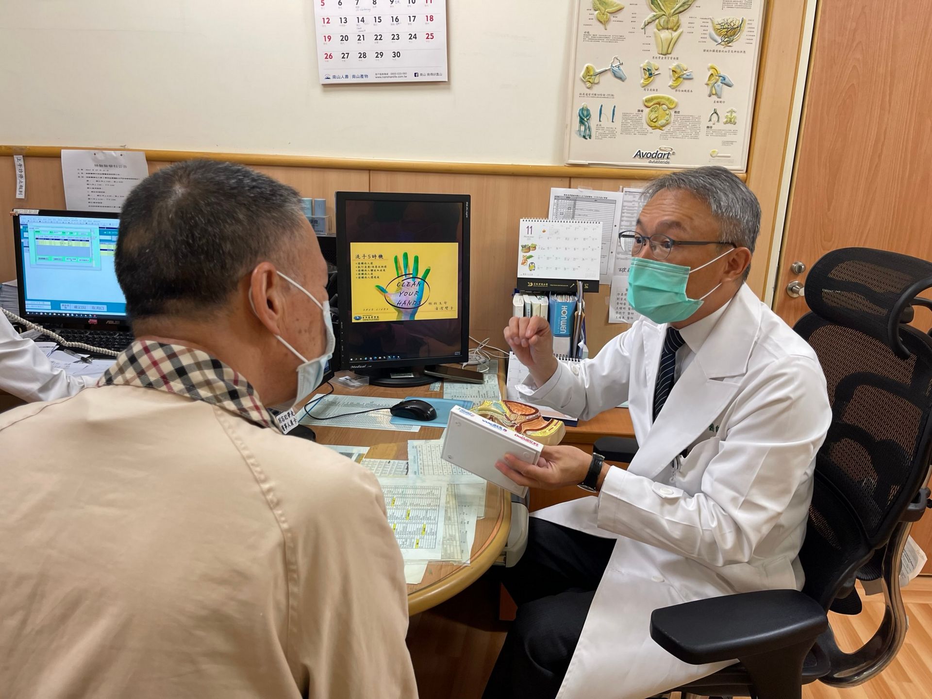裘坤元醫師（右）向王先生（左）說明術後漏尿觀察重點，並提醒他定期回診追蹤。