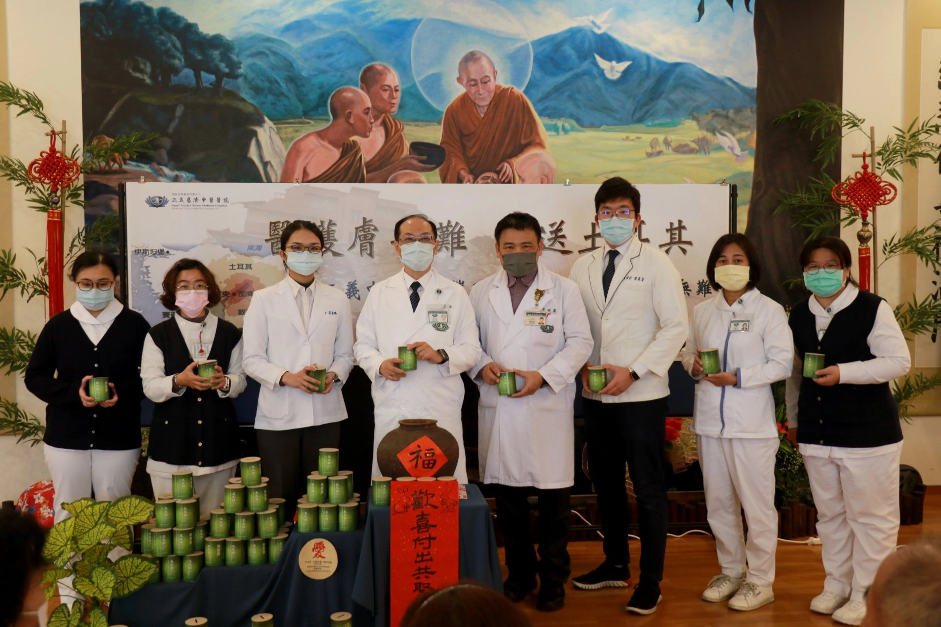 葉家舟院長（左四）帶領醫護團隊齊聚佛陀問病圖前，為土耳其災民祈禱並募心募愛。