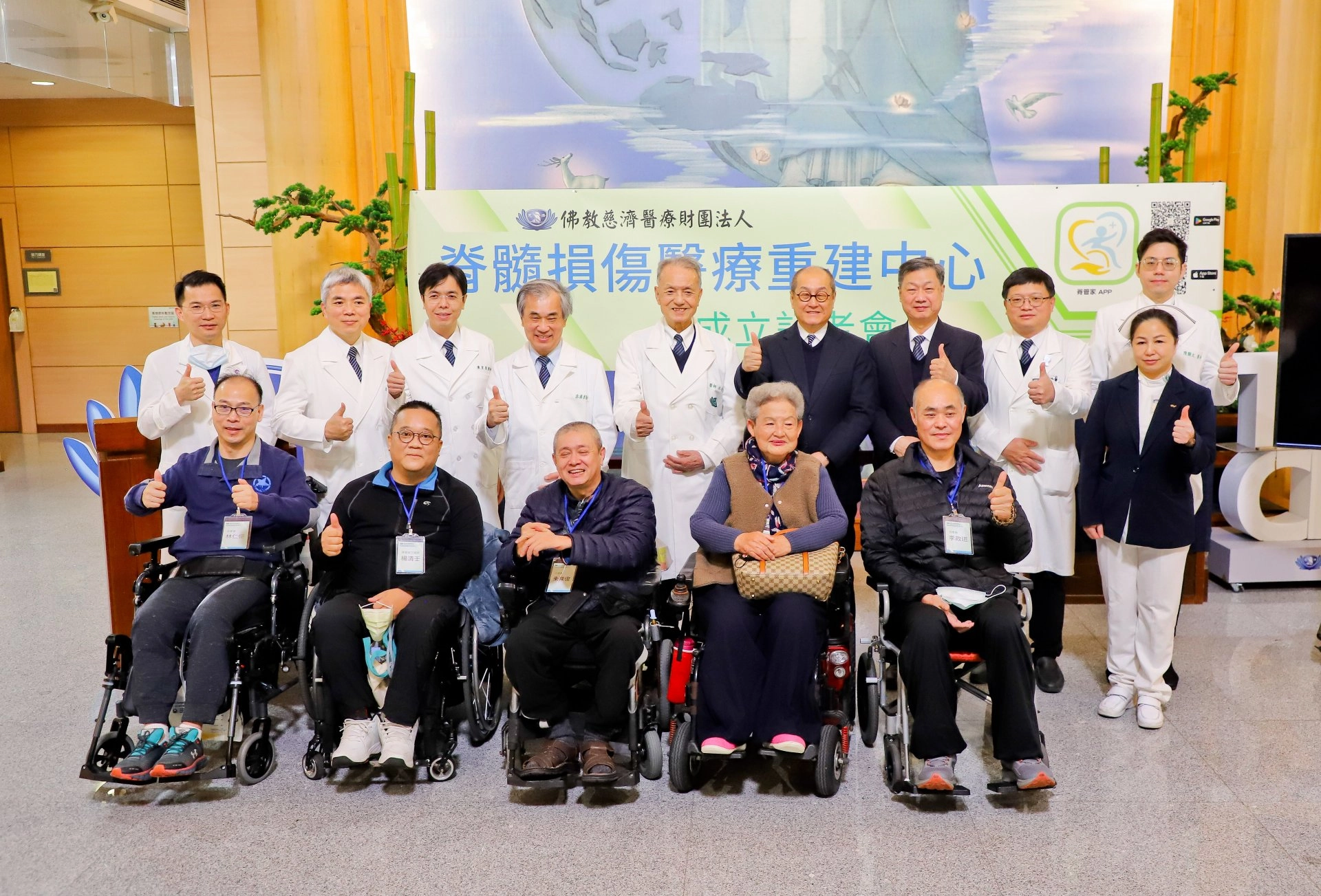 慈濟醫療志業脊髓損傷醫療重建中心團隊與分享的傷友合影，前排左起分別是傷友林仁傑、楊清壬、朱陳復、林貴子、李政道，後排左起神經外科部主任蔡昇宗、復健醫學部主任梁忠詔、泌尿部泌尿部兒童泌尿科主任陳聖復、慈濟醫療法人副執行長郭漢崇、執行長林俊龍、慈濟基金會副執行長劉濟雨、慈發處主任呂芳川、骨科部主任吳文田、護理部主任鍾惠君、骨科主治醫師陳顥文。