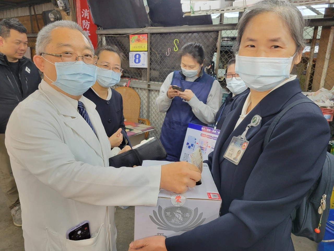 牙科部特殊需求者牙科李彝邦主任（左）與財務部張素鳳主任，進入果菜市場跟民眾講救援土耳其震災歷史與意義。