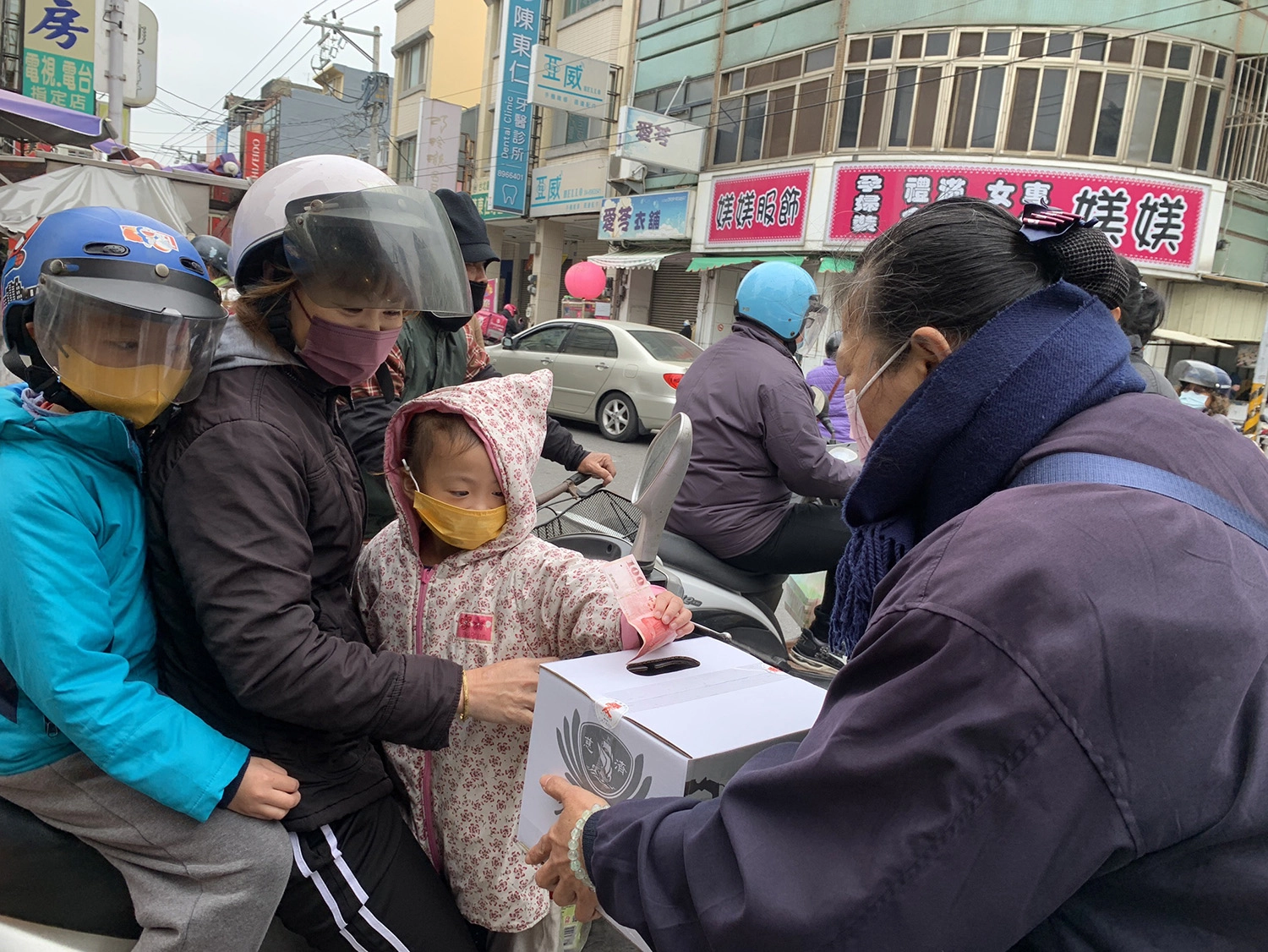 2月25日彰化慈濟走上街頭募心募愛，一位女士帶著小孩來捐款。(圖為慈濟基金會提供)