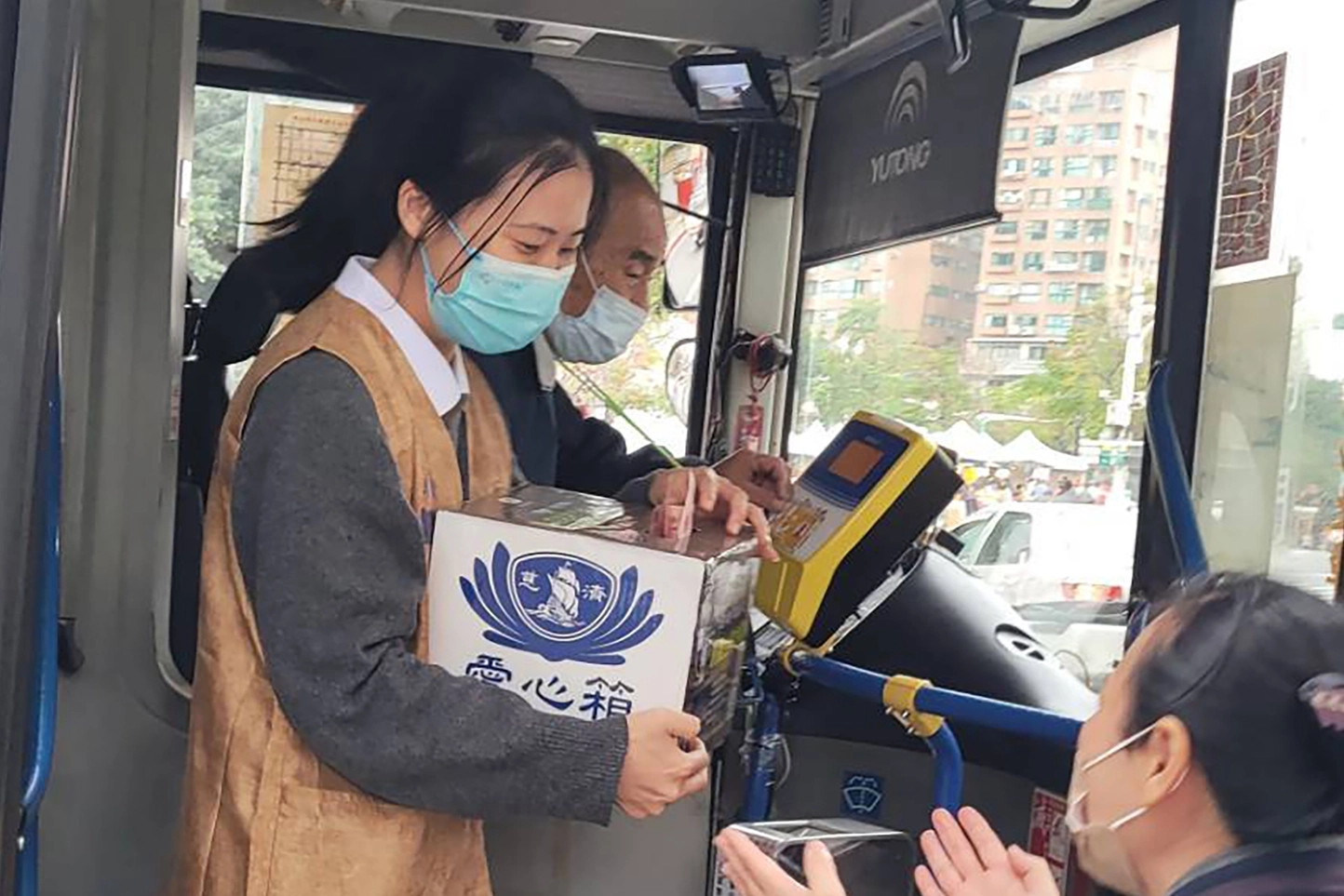 乘客下車後停等紅綠燈的公車司機，請志工抱愛心箱上公車讓他為土耳其盡一點心力。