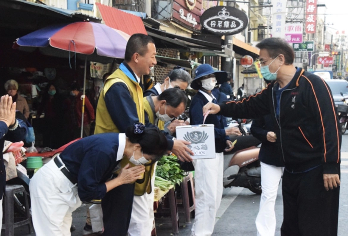 在菜市場加入勸募行列的東港鎮鎮長黃禎祥(左二)，也一起穿起慈濟背心站在街頭參與勸募。