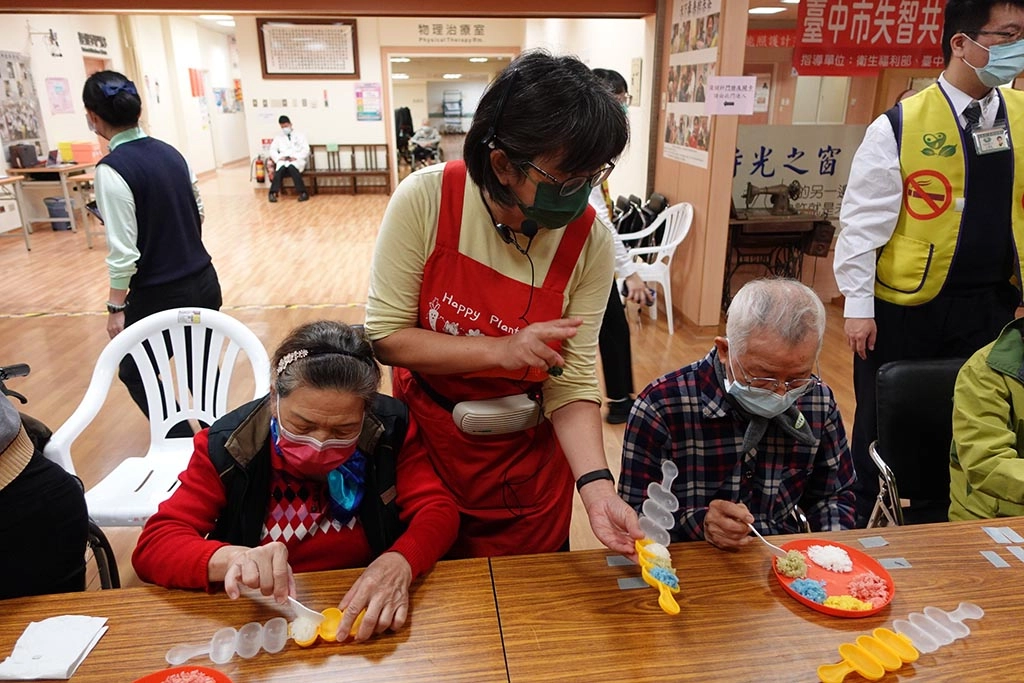 園藝治療師洪榛騏老師（中）指導長輩動手做五行飯糰。