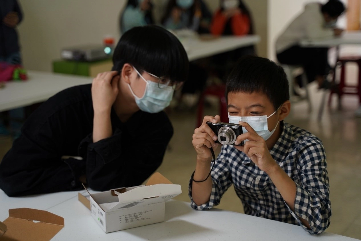 攝影志工陪伴孩子一起學習基礎相機使用規則(社團法人臺灣兒少玩心教育協會提供)