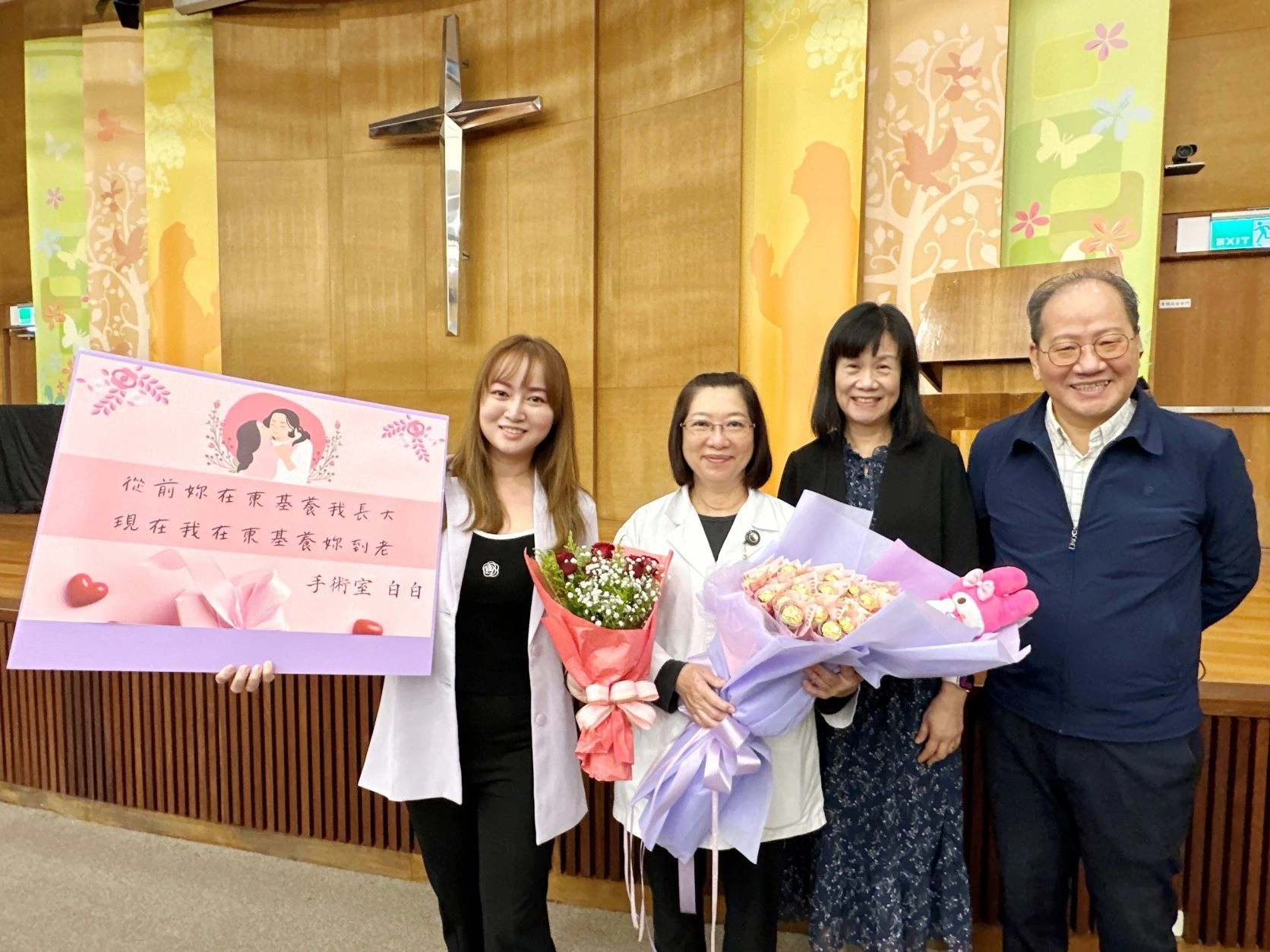 台東基督教醫院藥劑科藥師林宜靜（左二）、手術室護理師白蕙瑄（左一）是母女檔。林宜靜在農曆過年前榮退，白蕙瑄特地送上真鈔巧克力花束及特製告白卡。母女倆與東基醫療財團法人執行長呂信雄（右一）、吳方芳（右二）賢伉儷合照留念。