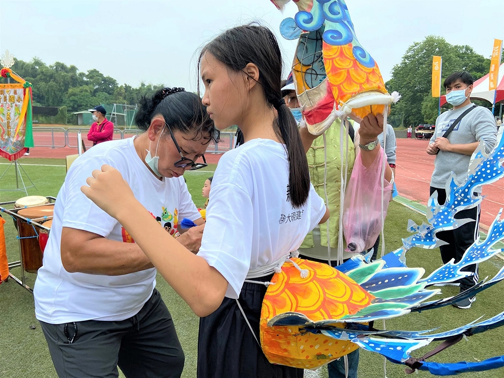 鄭宇芝老師賽前親手幫學生繫緊繩，如給予他們力量及祝福。