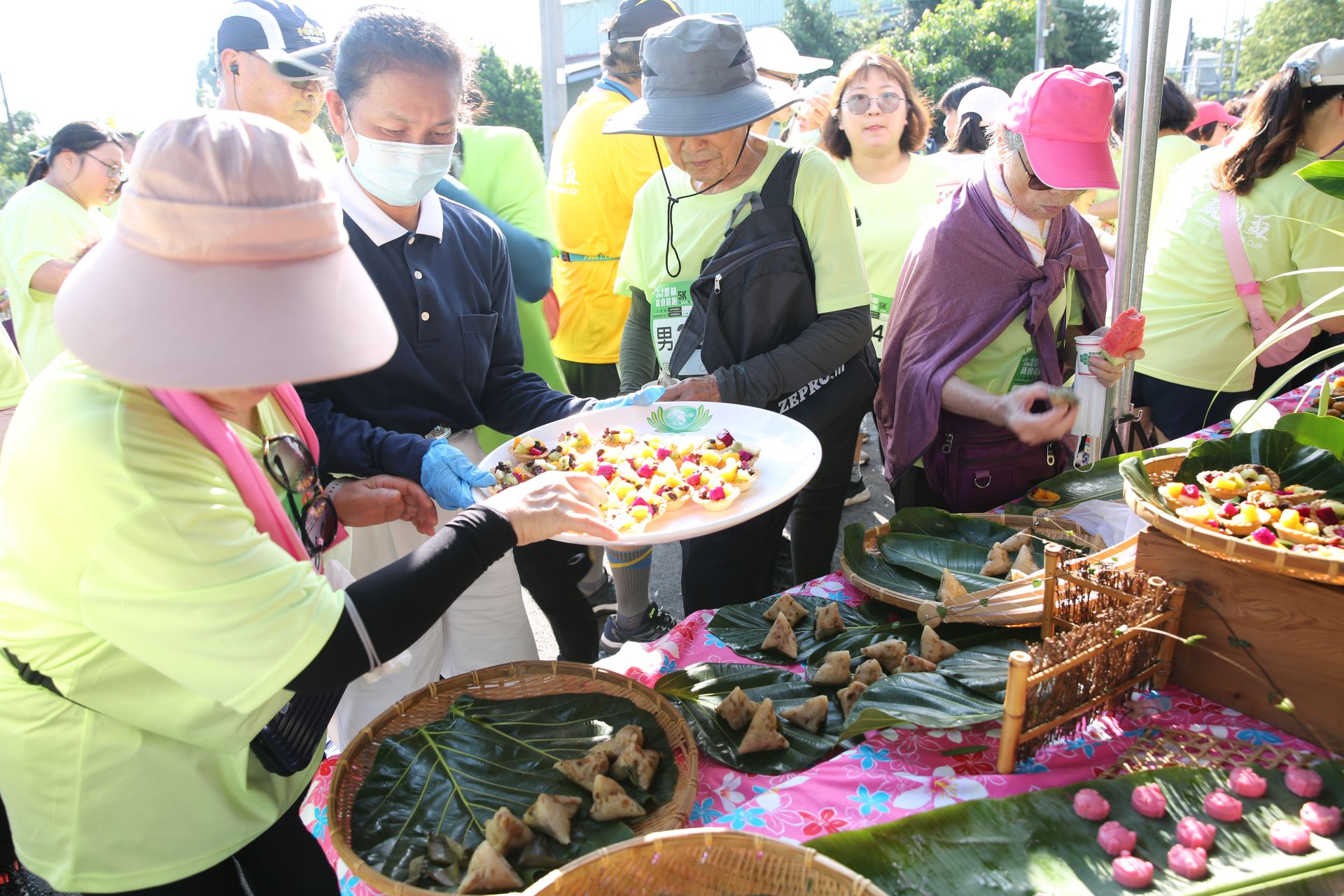 天氣炙熱,參加5K跑者快樂來到一口蔬食補給站,志工端上點心為跑者補充量能。