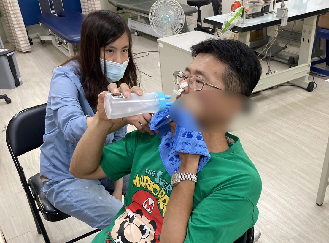 阿志大哥在陽光治療師指導下練習以口進食