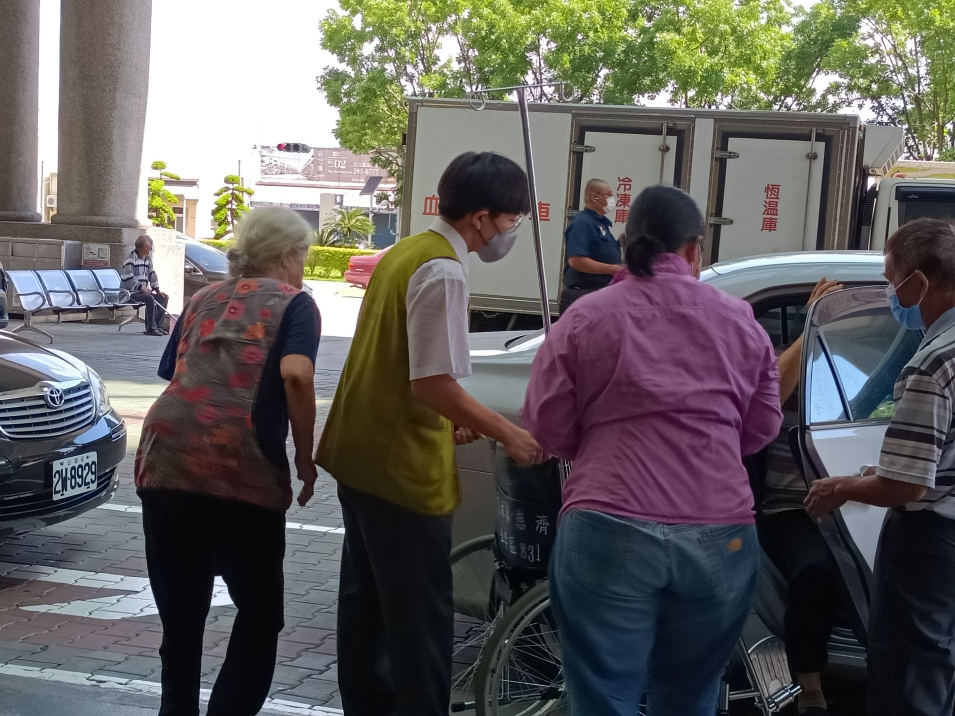 不受醫院外酷熱的氣溫影響,學生積極推著輪椅迎上行動不便的患者。