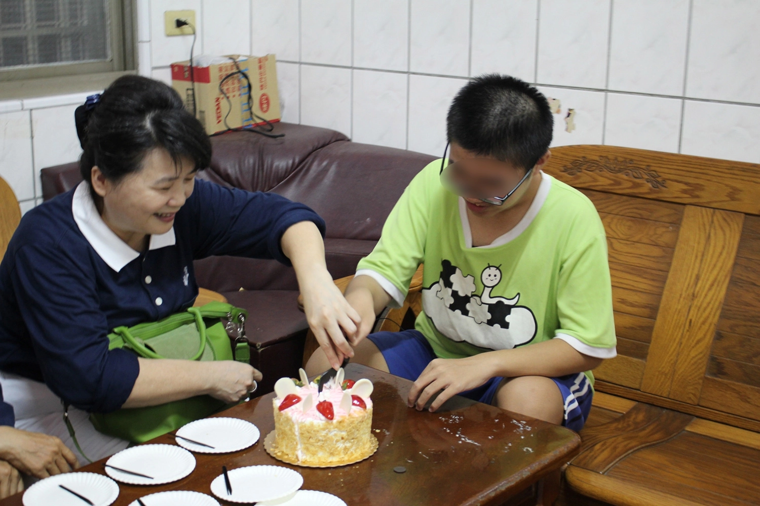 志工參與了阿毅許多人生成長的階段。圖為志工幫阿毅（右一）切蛋糕。