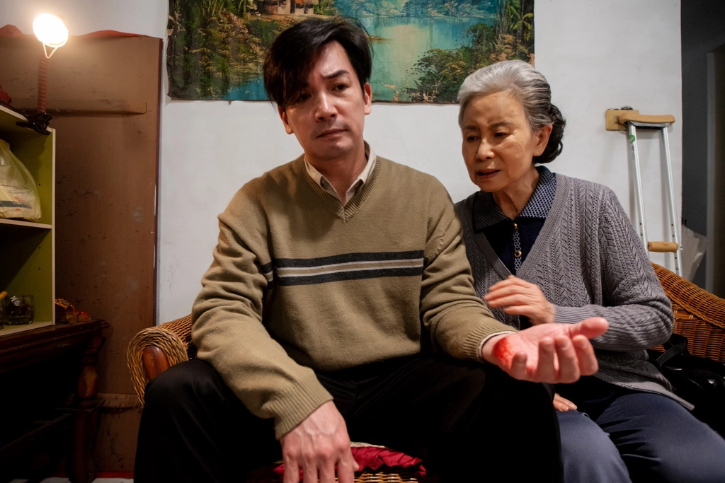 伊正(左)在搜尋者飾演落魄歌手，需要訪視志工(右，林乃華飾)照顧
