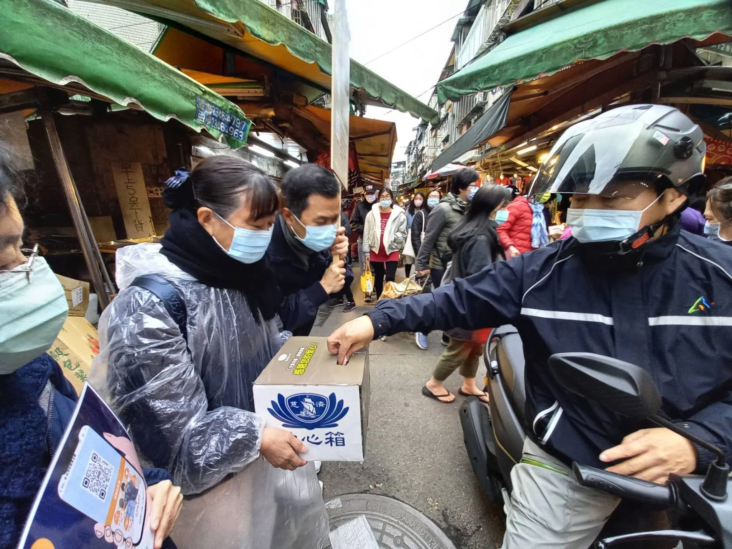 志工走入街頭向社會大眾募心募愛。雙手捧著募款箱和宣導舉牌，在汐止橫科力行市場，往來民眾都紛紛投下愛心馳援。