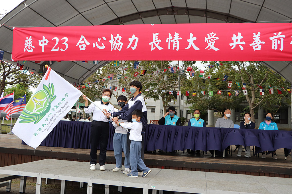 校長授旗給授旗予石絢宇、陳哲洋及楊普賢三位學生代表。