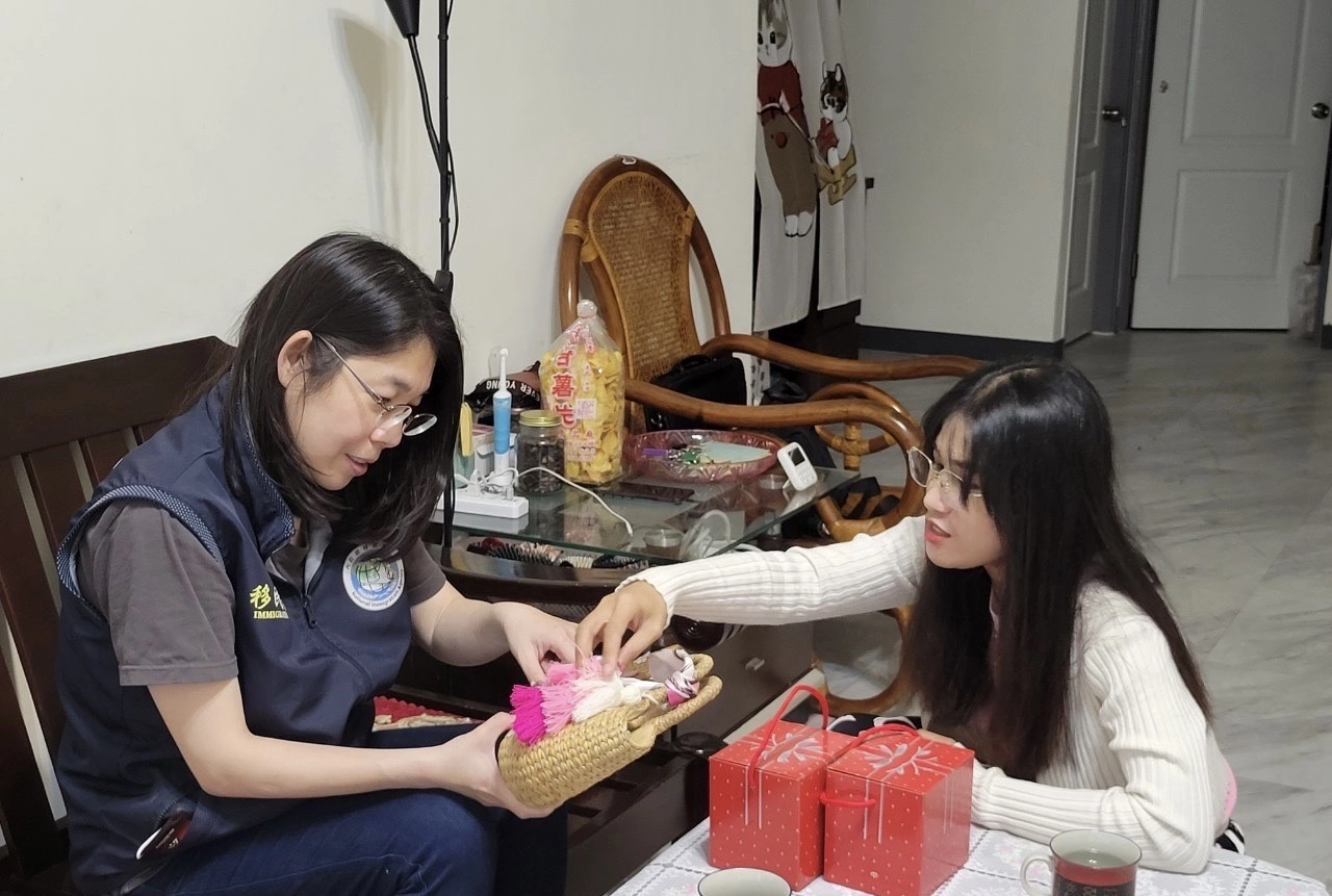 潘喜玲(右)向移民署新北站同仁介紹柬埔寨編織包。