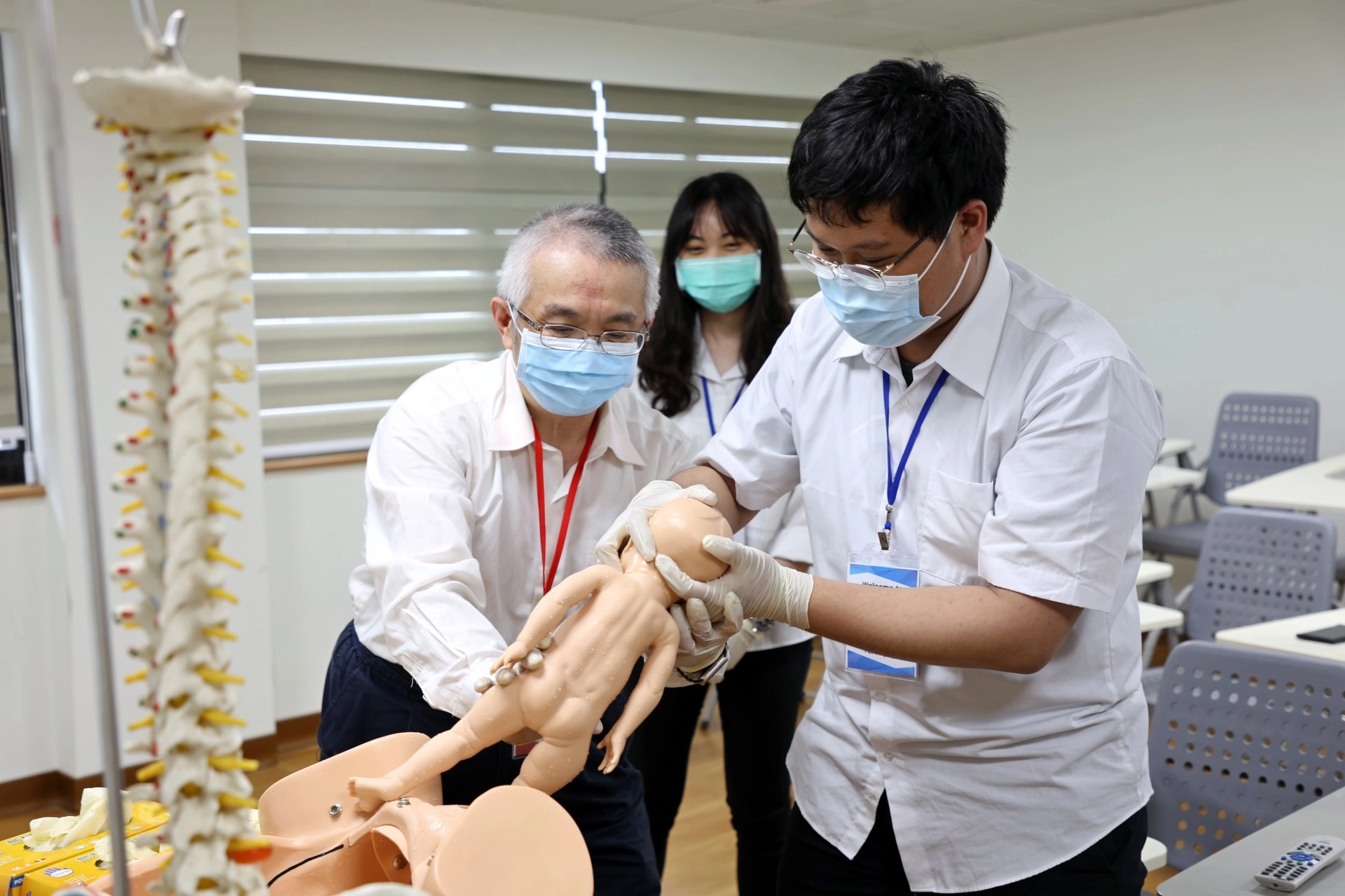 高聖博主任指導醫學生，當胎兒從母親的產道出來時，該如何擺放手勢、如何調整角度，才能夠以最安全的姿勢讓寶寶平安誕生。