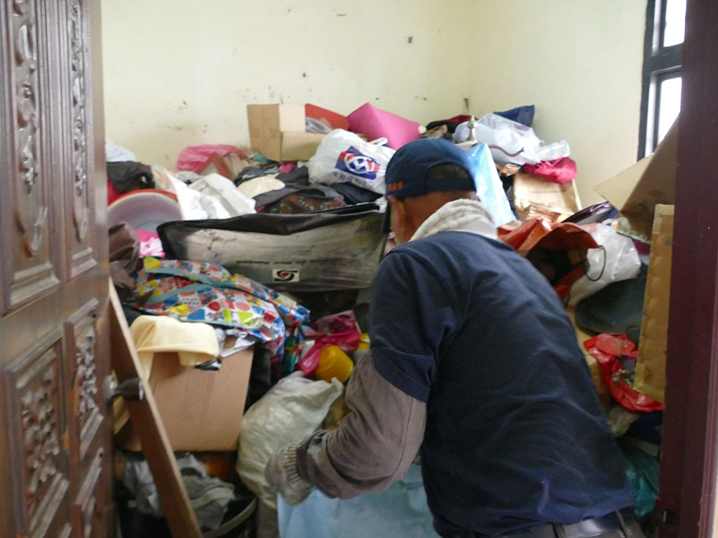南投慈濟志工為獨居長者清理環境，細心整理成堆的雜物。